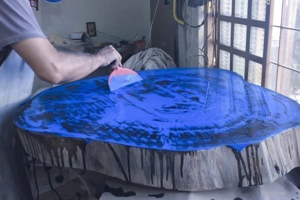 homem resinando madeira em azul