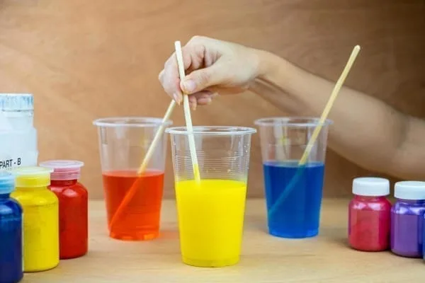 tres recipientes com resinas coloridas